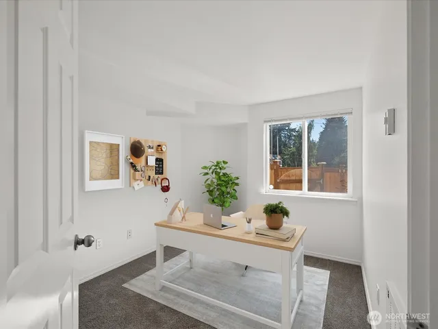 a view of a workspace with furniture and window