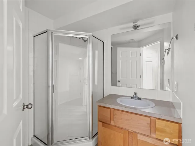 a bathroom with a sink shower and a mirror