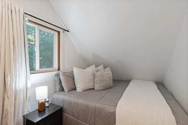 a bed sitting in a bedroom next to a window