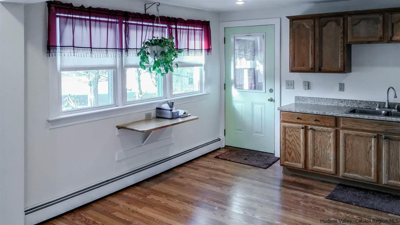 735 Springtown Road Tillson, NY 12486 - Photo 9 of 35 a kitchen with granite countertop white cabinets and window