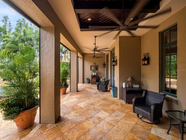 a view of a swimming pool with lawn chairs and plants