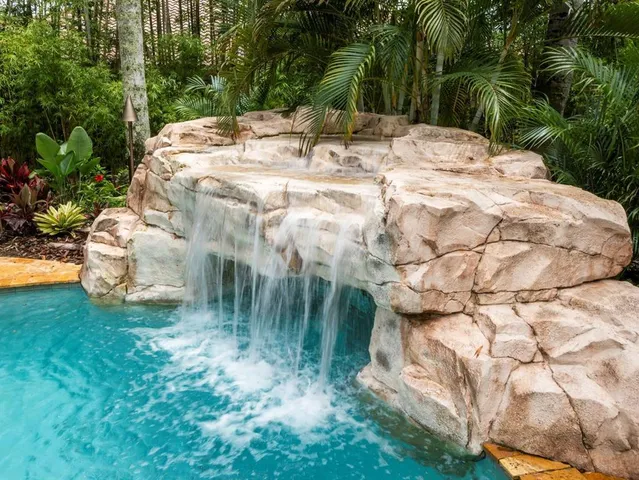 a view of swimming pool with red chairs