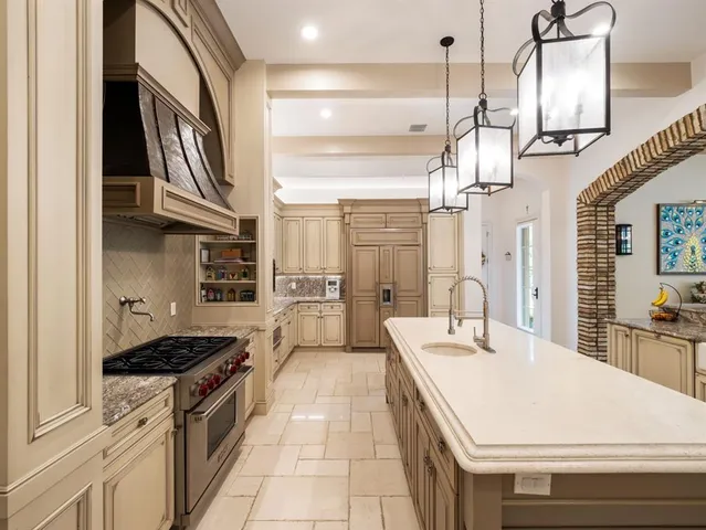 a view of a kitchen with a sink a chandelier and living room view