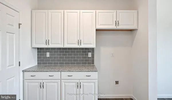 a kitchen with granite countertop white cabinets and a white stove