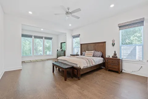 a spacious bedroom with a bed a chandelier and large window