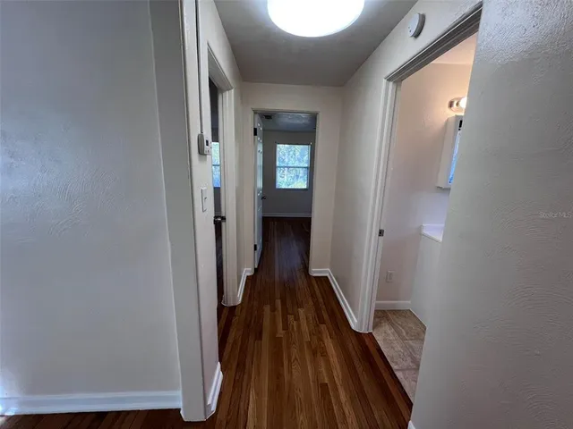 a view of a hallway with wooden floor