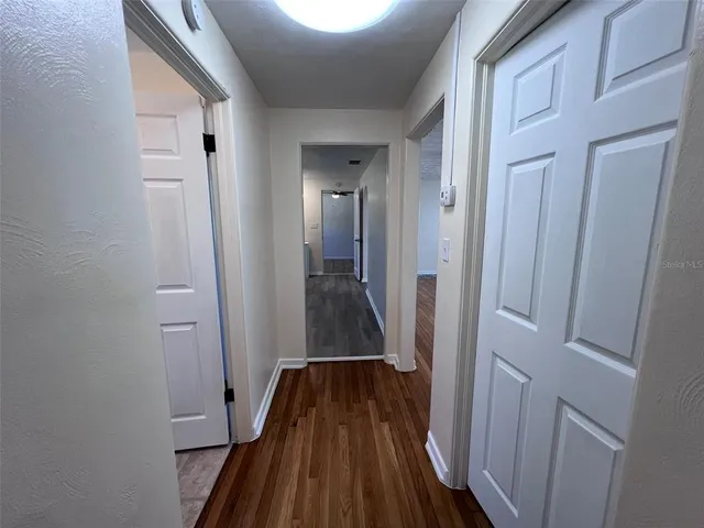 a view of a hallway with wooden floor and staircase