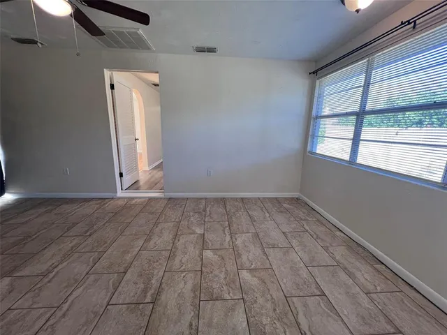 an empty room with a fireplace and windows