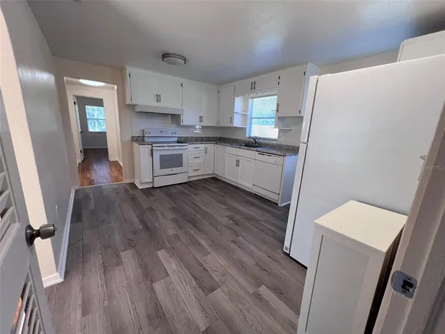 a kitchen with white cabinets and white appliances