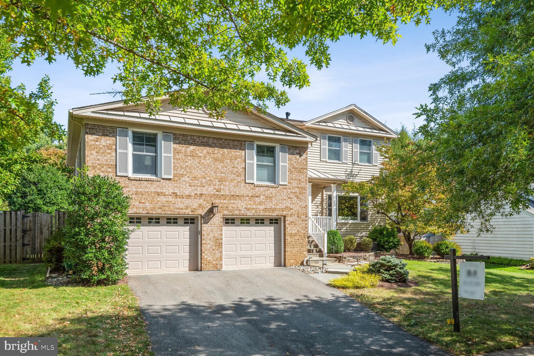 1507 Blue Meadow Road Potomac, MD 20854 - Photo 2 of 36 a front view of a house with a yard garage and outdoor seating