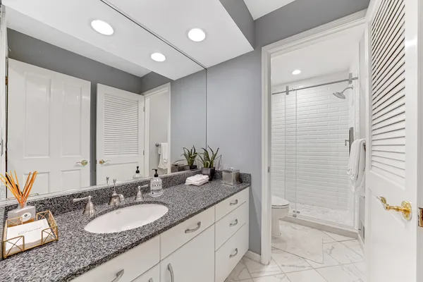 a bathroom with a granite countertop sink and a mirror