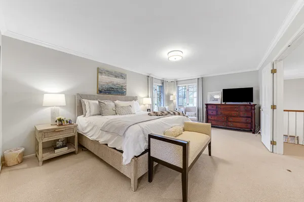 a spacious bedroom with a bed and flat screen tv
