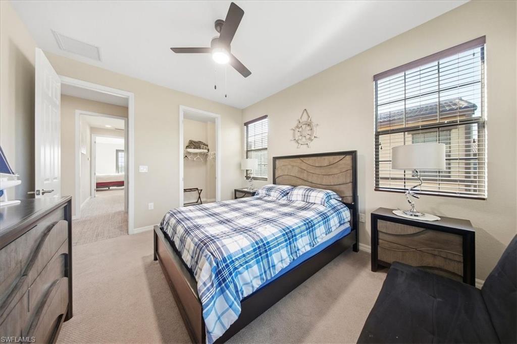 9063 Capistrano Street North, Unit 4401 Naples, FL 34113 - Photo 17 of 50 a bedroom with a large bed and a chandelier