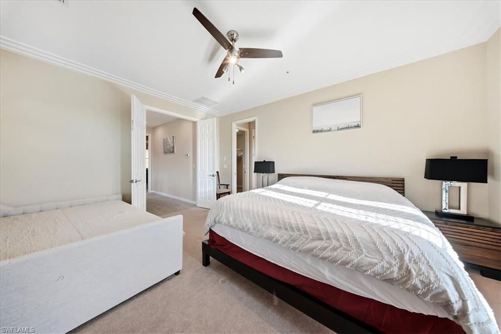 9063 Capistrano Street North, Unit 4401 Naples, FL 34113 - Photo 21 of 50 a spacious bedroom with a bed and a lamp