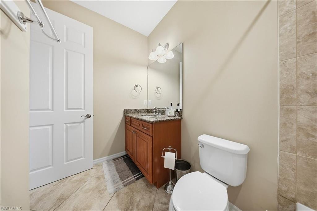 9063 Capistrano Street North, Unit 4401 Naples, FL 34113 - Photo 25 of 50 a bathroom with a toilet a sink and mirror
