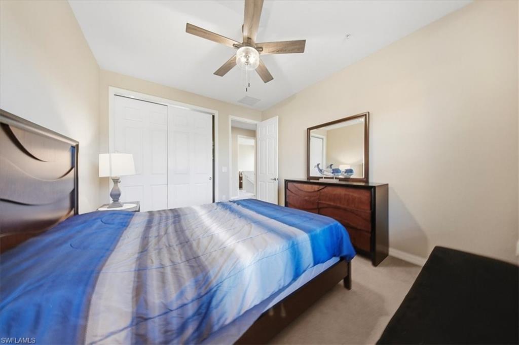 9063 Capistrano Street North, Unit 4401 Naples, FL 34113 - Photo 36 of 50 a bedroom with a bed and a chandelier