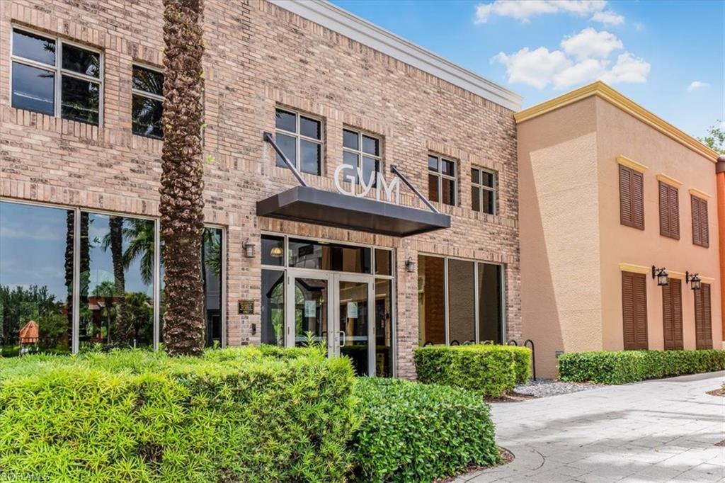 9063 Capistrano Street North, Unit 4401 Naples, FL 34113 - Photo 44 of 50 a view of a brick building next to a yard