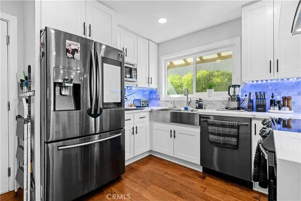 a kitchen with stainless steel appliances a refrigerator sink and cabinets