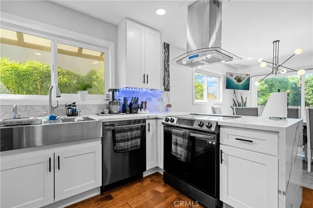 a kitchen with a stove a sink and a window