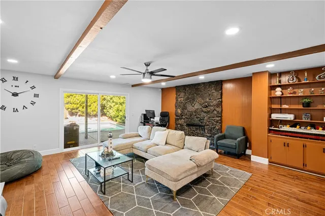 a living room with fireplace furniture and a large window