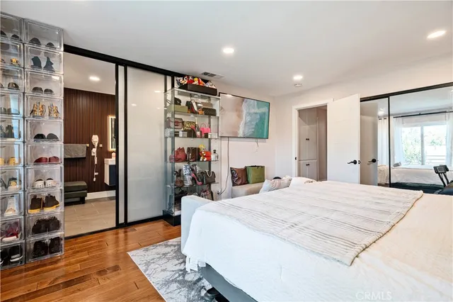 a large bedroom with a bed and wooden floor