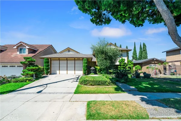 a front view of a house with a yard and potted plants