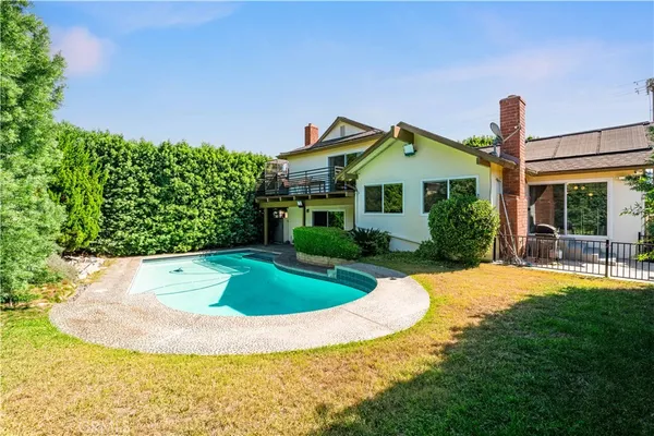 a view of a house with a yard and potted plants
