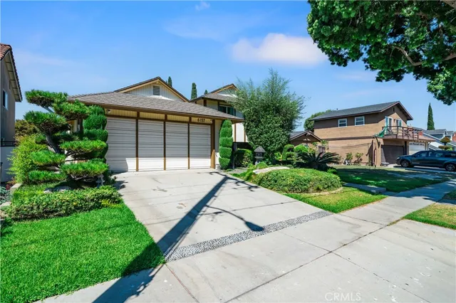 a front view of a house with a yard and potted plants