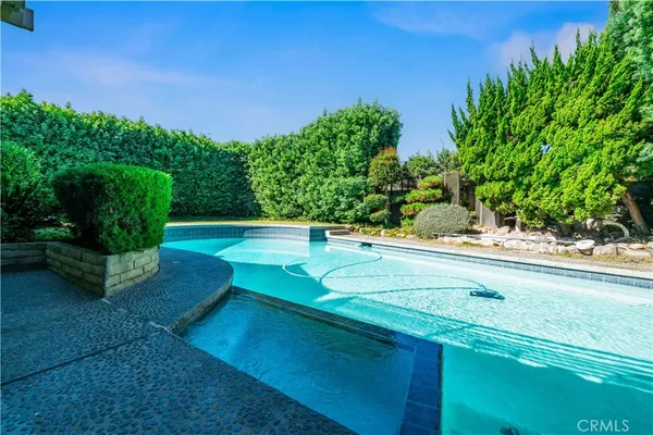 a view of yard with swimming pool and green space