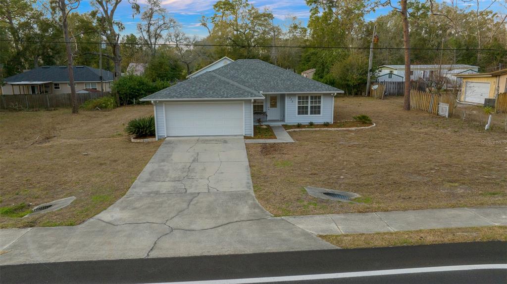 a front view of a house with a yard and trees