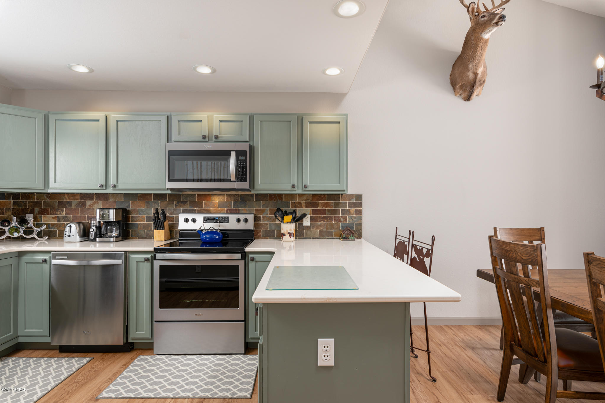 443 Muse Drive, Unit 2 Fraser, CO 80442 - Photo 4 of 26 a kitchen with a sink a stove top oven a dining table and chairs