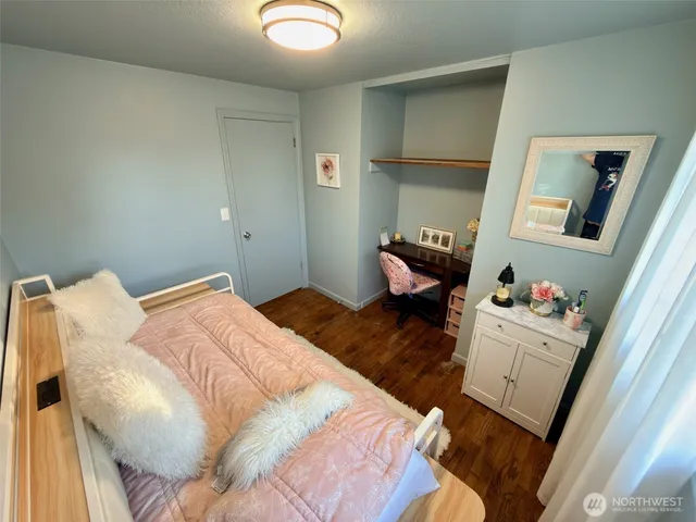 a bedroom with a bed and wooden floor