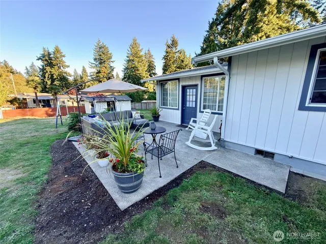 a view of a chair and table in backyard of the house