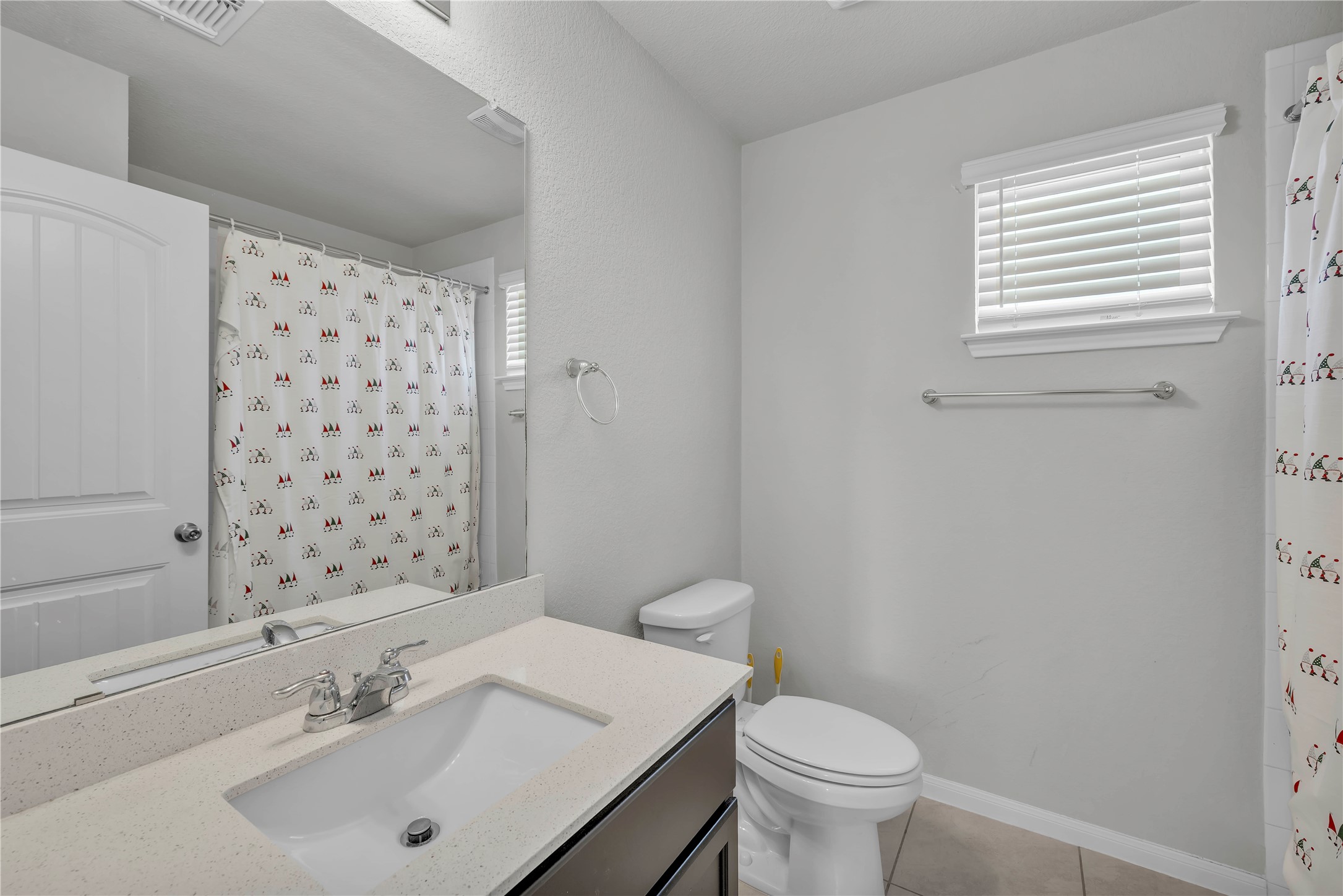 6813 Ranchito Drive Austin, TX 78744 - Photo 12 of 16 a bathroom with a sink a toilet and shower curtain