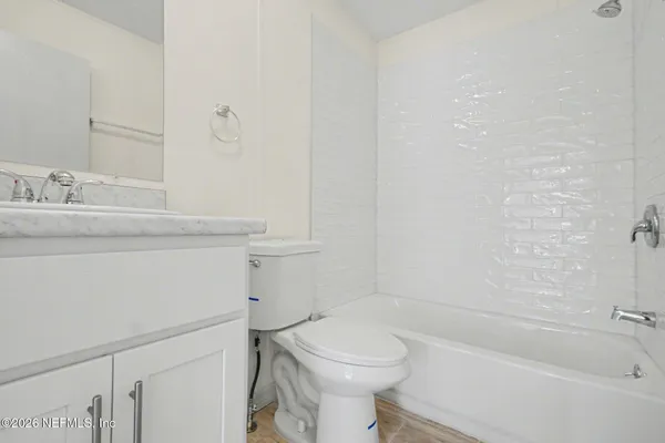 a bathroom with a granite countertop toilet sink and mirror