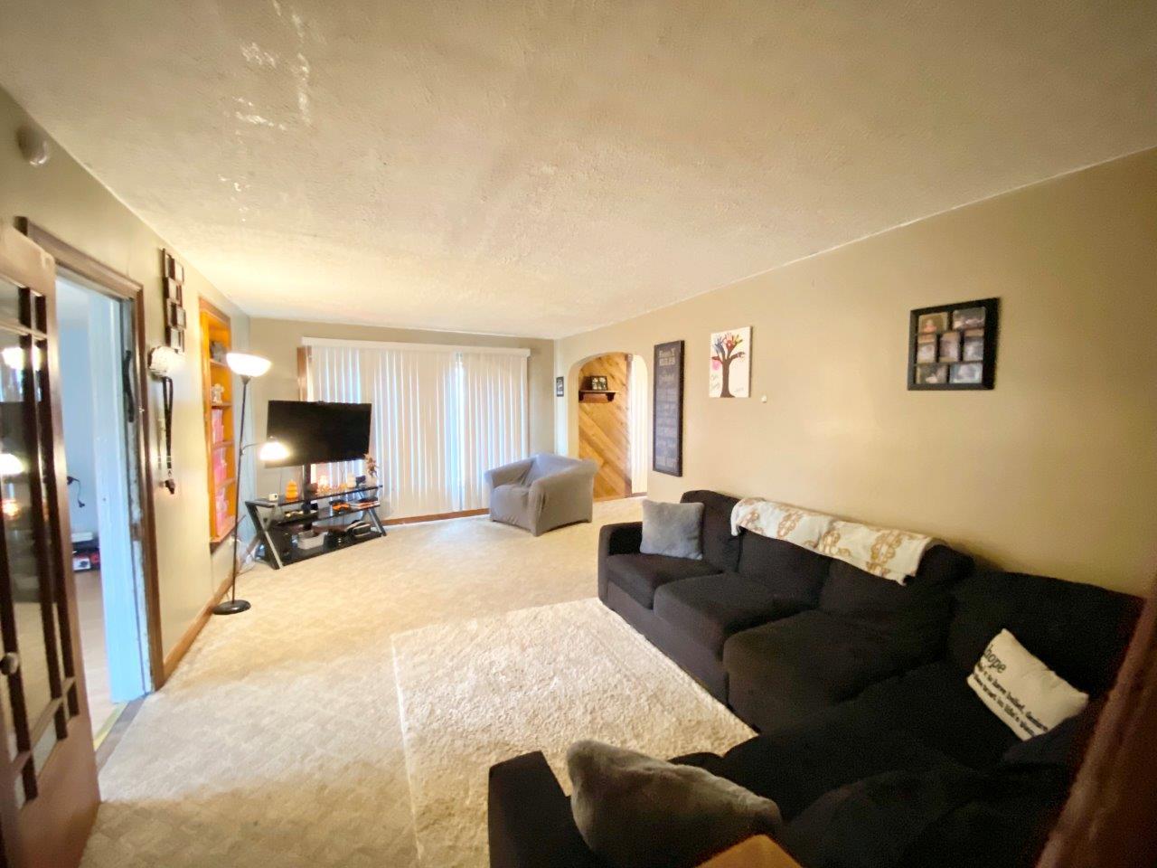 703 East Larue Street Streator, IL 61364 - Photo 7 of 38 a living room with furniture a flat screen tv and a refrigerator