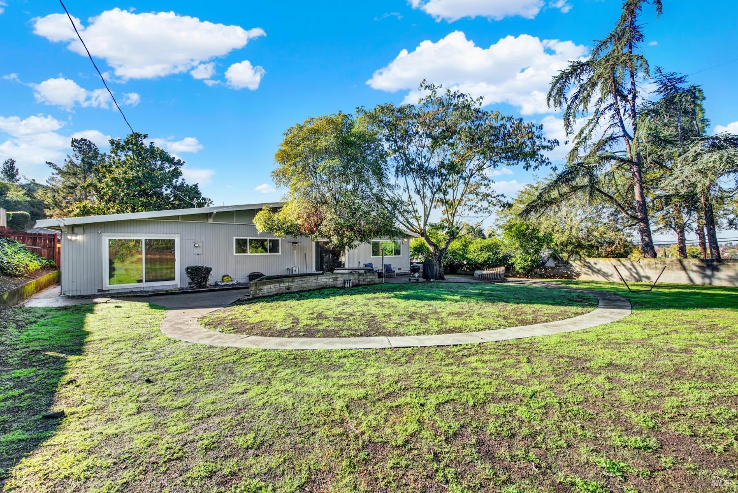 4118 Georgia Street Vallejo, CA 94591 - Photo 42 of 56 a view of a house with a big yard and potted plants and large tree
