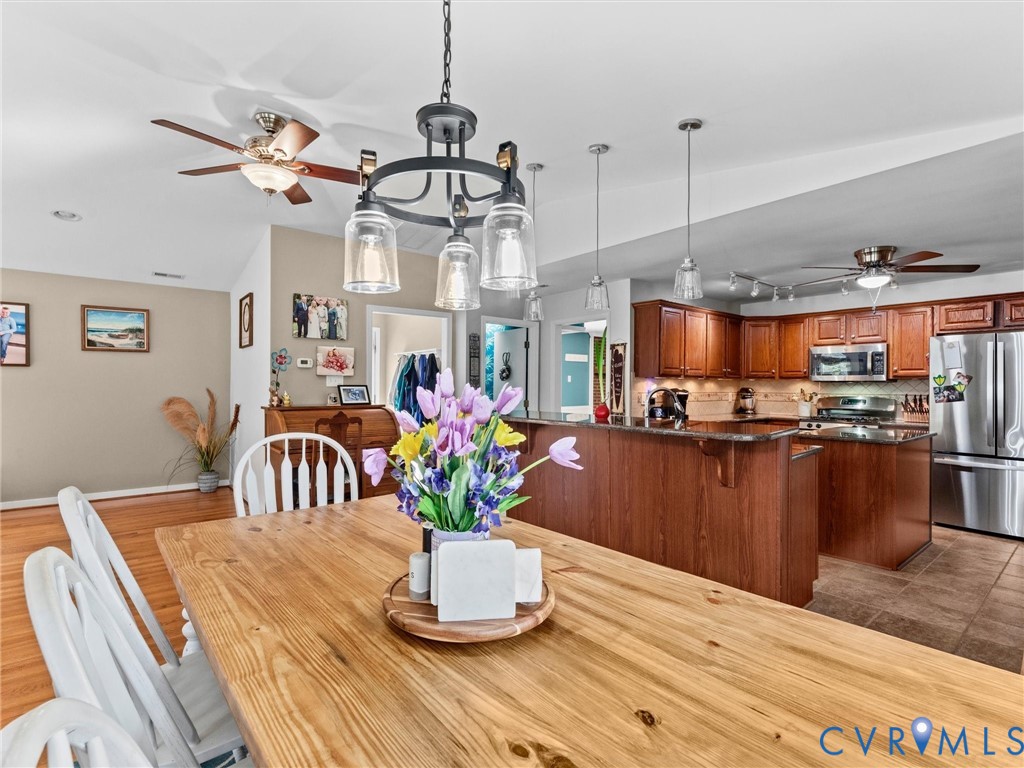 10488 Old Telegraph Road Ashland, VA 23005 - Photo 30 of 69 a dining room with wooden floor a chandelier a wooden table and chairs