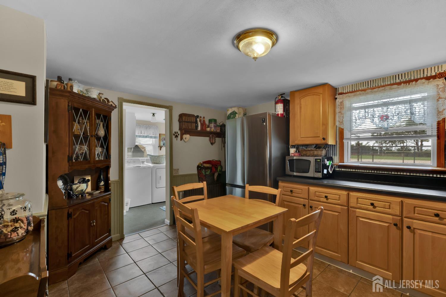 18 Pine Street Keyport, NJ 07735 - Photo 14 of 31 a kitchen with stainless steel appliances kitchen island granite countertop a refrigerator a stove top oven and a dining table with wooden floor