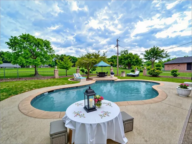 a view of a green yard with large trees