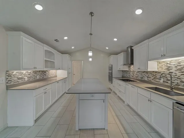 a large kitchen with kitchen island a sink stainless steel appliances and cabinets