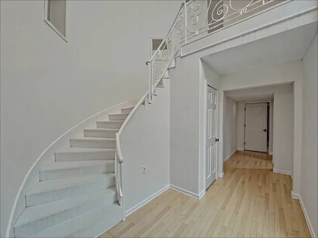 a view of a hallway with wooden floor and entryway