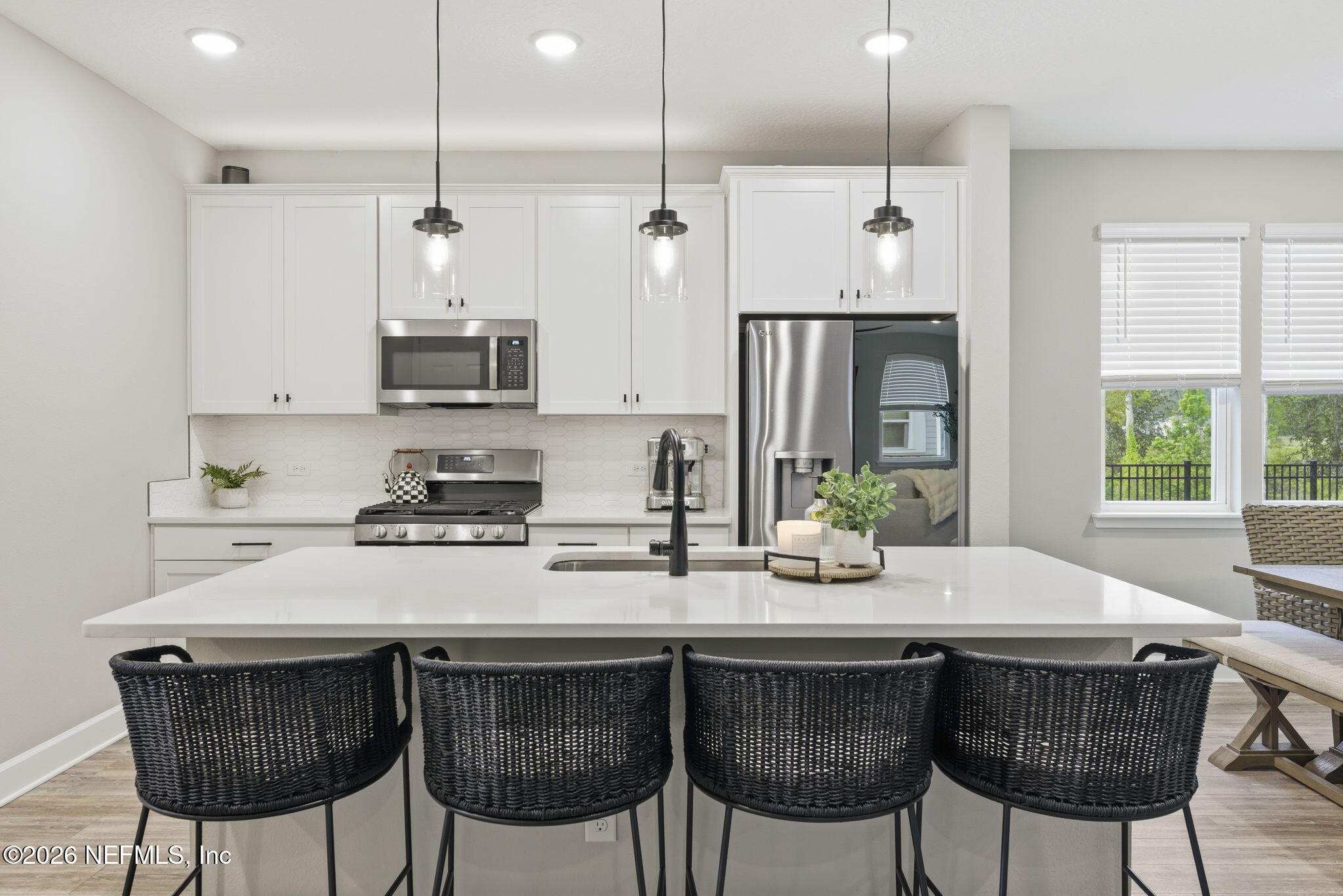 301 Field Flower Way St. Augustine, FL 32092 - Photo 11 of 58 a kitchen with stainless steel appliances a dining table chairs and wooden floor