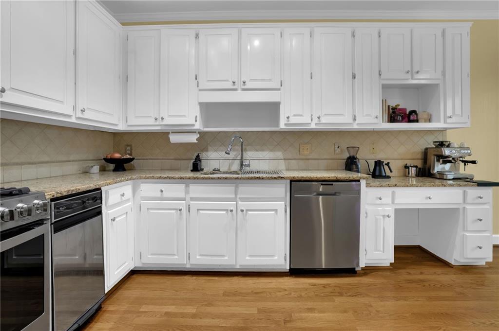 7155 Roswell Road, Unit 14 Atlanta, GA 30328 - Photo 12 of 35 a kitchen with granite countertop white cabinets and stainless steel appliances