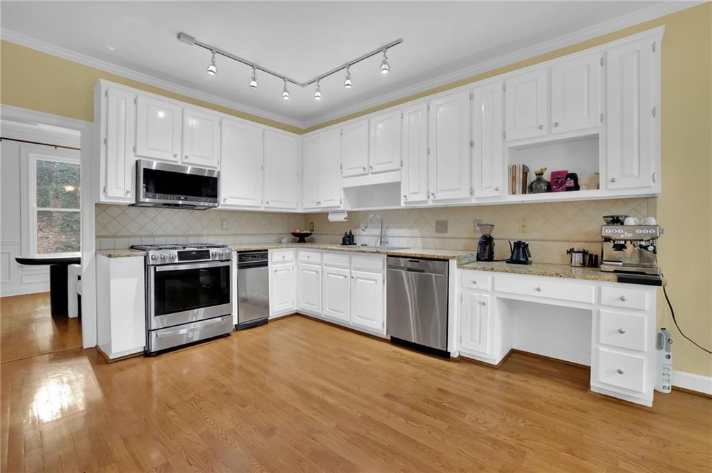 7155 Roswell Road, Unit 14 Atlanta, GA 30328 - Photo 13 of 35 a kitchen with stainless steel appliances granite countertop a stove top oven a sink and white cabinets