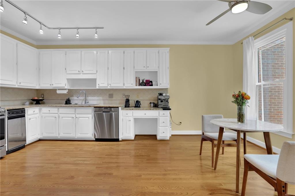 7155 Roswell Road, Unit 14 Atlanta, GA 30328 - Photo 16 of 35 a kitchen with stainless steel appliances white cabinets and wooden floor