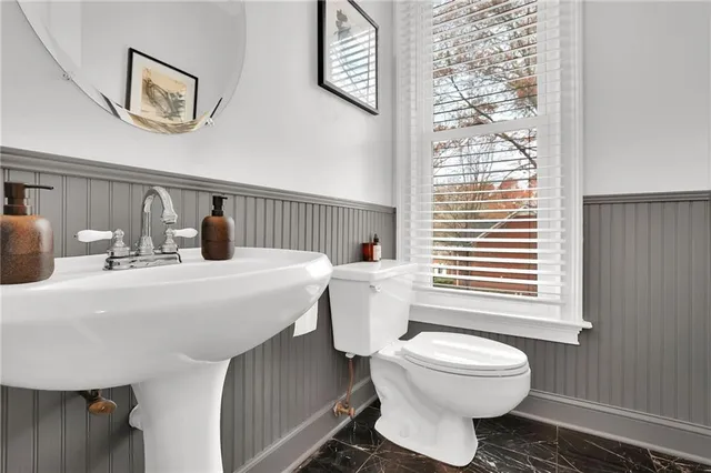 a bathroom with a toilet a sink and a window