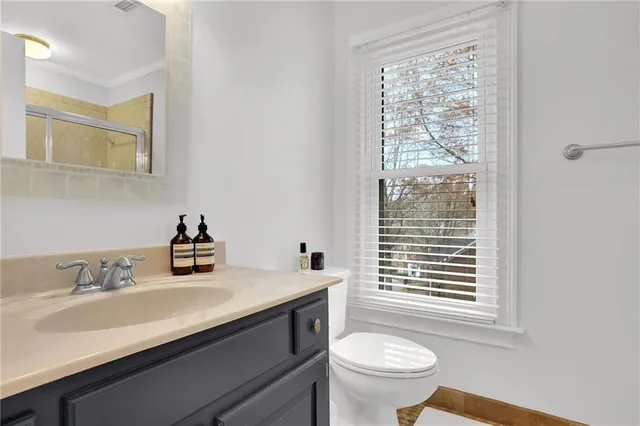 a bathroom with a sink a toilet and a window