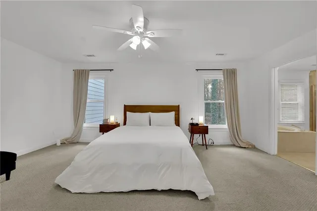 a spacious bedroom with a bed and a chandelier
