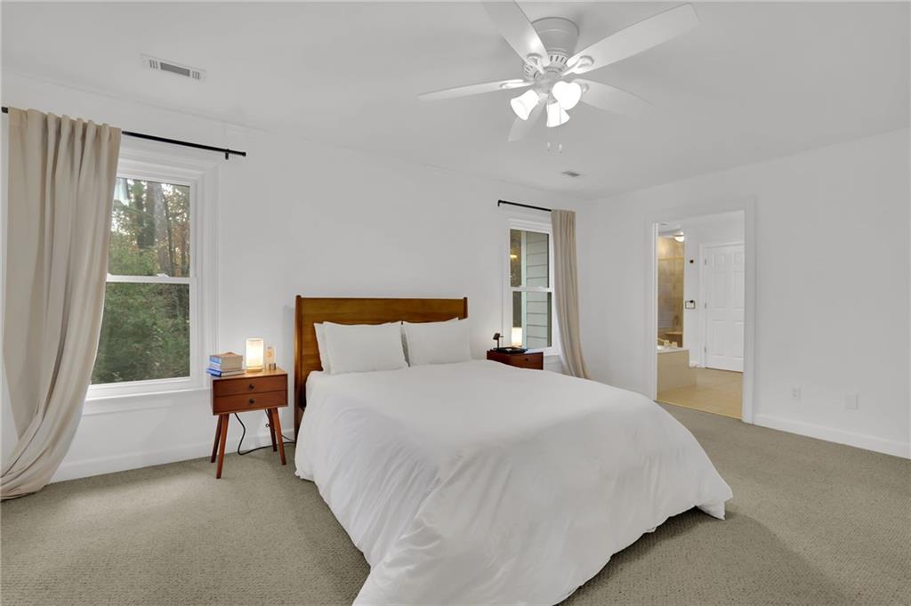 7155 Roswell Road, Unit 14 Atlanta, GA 30328 - Photo 24 of 35 a spacious bedroom with a bed and a chandelier